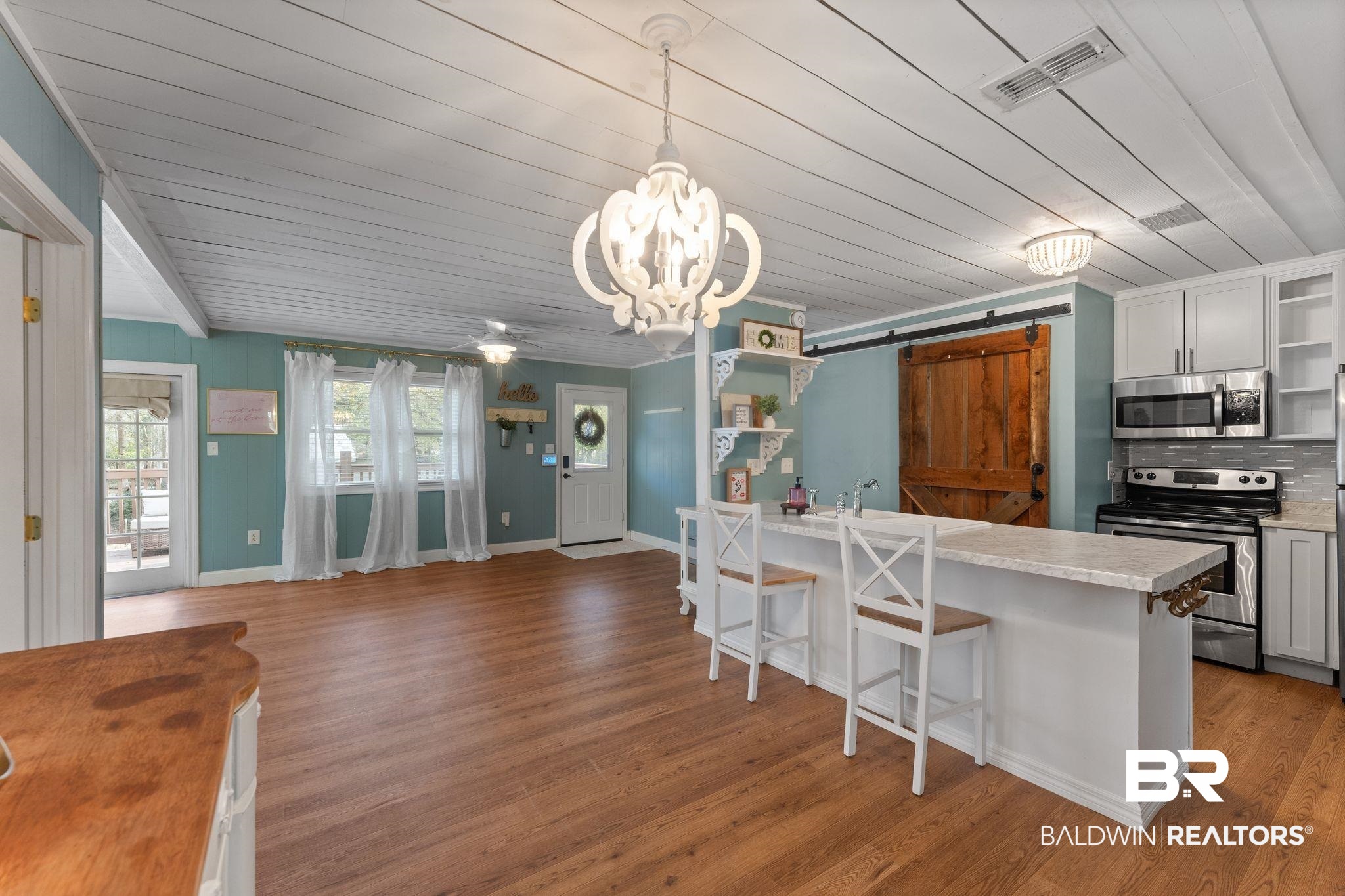 3881 Oregon Avenue Coden, AL 36523 - Photo 4 of 19 Kitchen featuring a barn door, light countertops, a breakfast bar area, stainless steel appliances, and ceiling fan