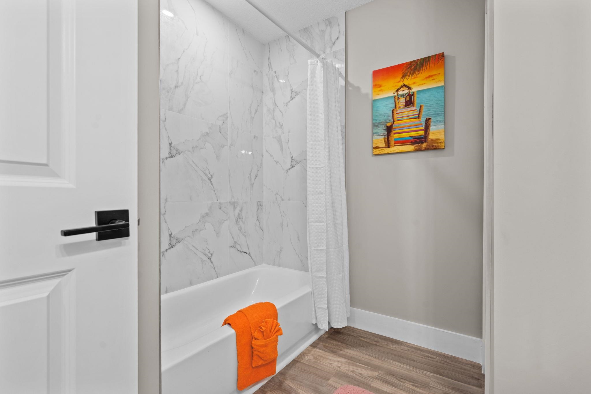 812 West 9th Street St. Augustine, FL 32084 - Photo 11 of 31 Bathroom with a combined bath / shower with marble appearance and wood finished floors