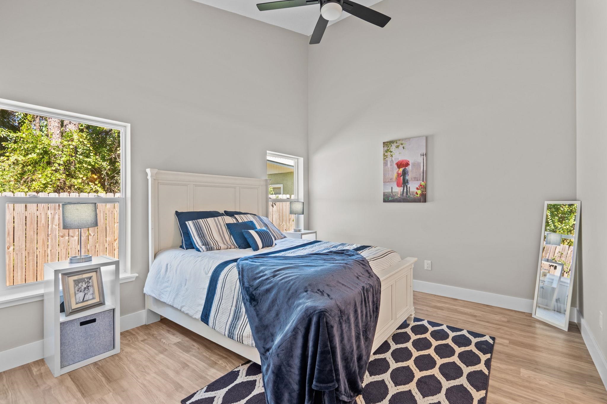 812 West 9th Street St. Augustine, FL 32084 - Photo 12 of 31 Bedroom with light wood-type flooring, a ceiling fan, and a high ceiling