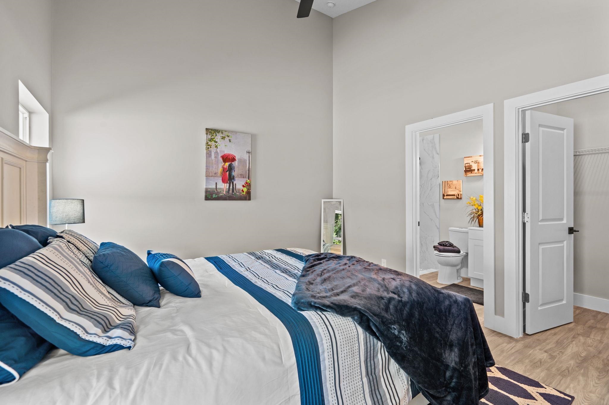 812 West 9th Street St. Augustine, FL 32084 - Photo 14 of 31 Bedroom featuring wood finished floors, a towering ceiling, and ensuite bathroom