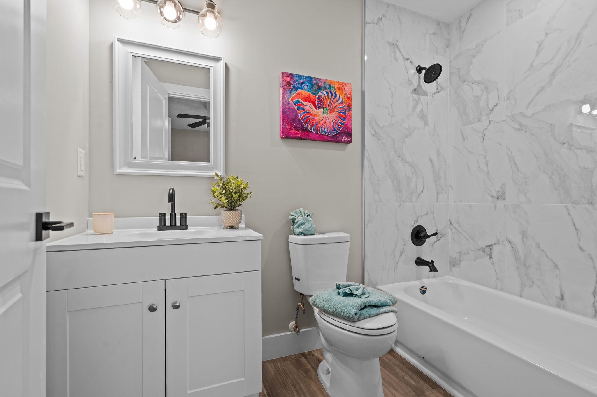 812 West 9th Street St. Augustine, FL 32084 - Photo 22 of 31 Full bathroom with vanity, tub / shower combination, and wood finished floors