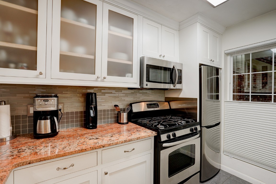 7920 Rockwood Lane, Unit 128 Austin, TX 78757 - Photo 12 of 36 a kitchen with granite countertop stainless steel appliances a stove a sink and a counter space