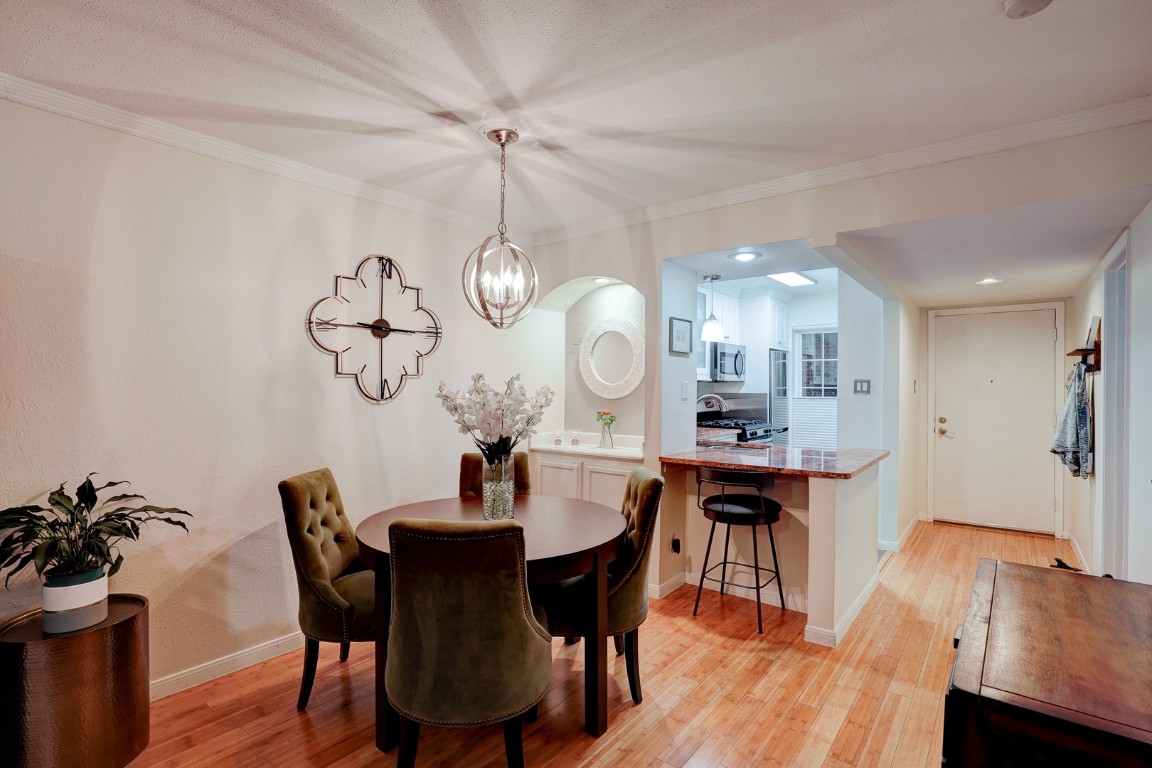 7920 Rockwood Lane, Unit 128 Austin, TX 78757 - Photo 7 of 36 a view of a dining room with furniture a chandelier and wooden floor