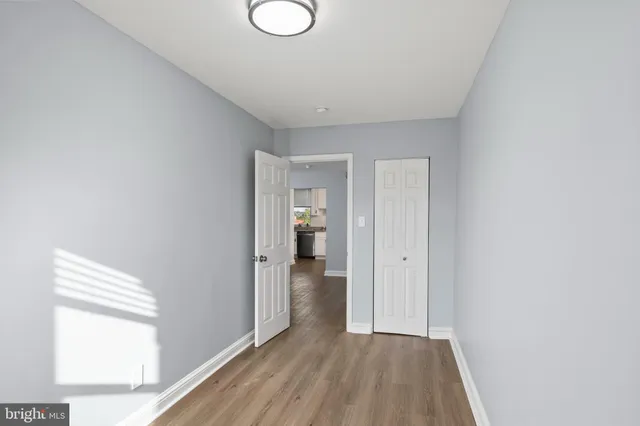 a view of hallway with bathroom and wooden floor