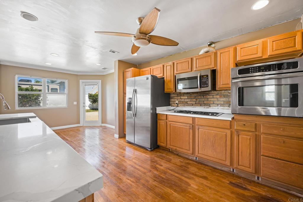 2548 Mesa Drive Oceanside, CA 92054 - Photo 10 of 33 a kitchen with stainless steel appliances granite countertop a refrigerator a stove microwave and cabinets