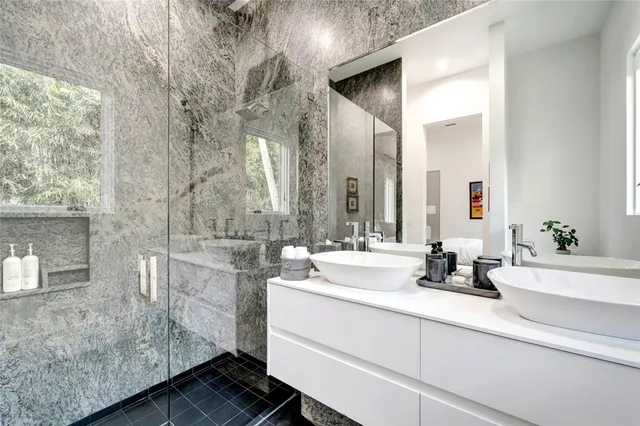 a bathroom with a double vanity sink mirror and shower