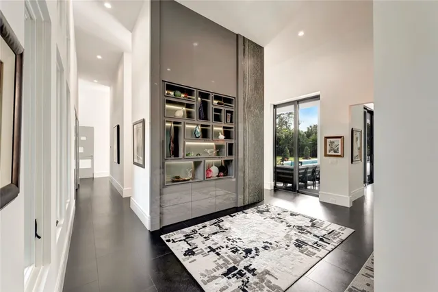 a view of a hallway with wooden floor and a living room