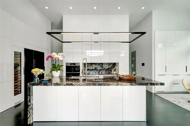 a kitchen with stainless steel appliances granite countertop a sink and a refrigerator