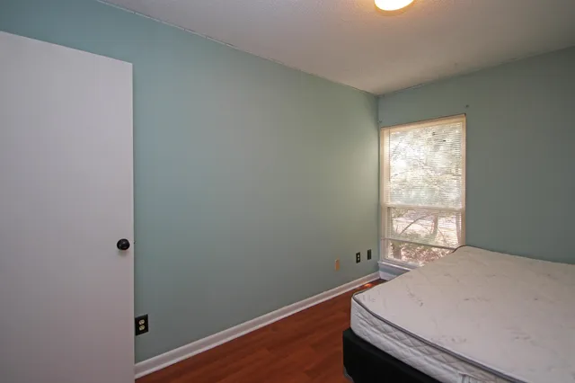 a bedroom with a bed and wooden floor
