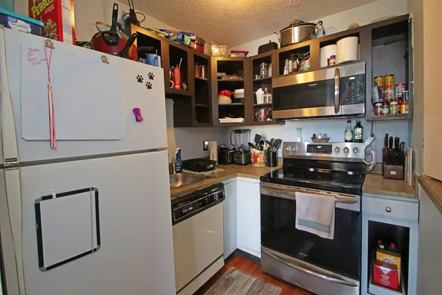 a kitchen with stainless steel appliances granite countertop a stove and a refrigerator