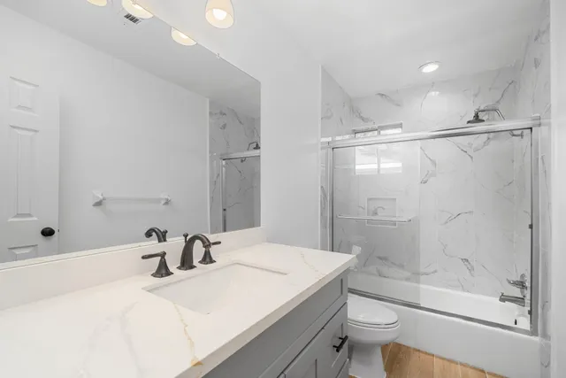 a bathroom with a sink toilet and shower