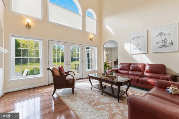 a living room with furniture a red rug and a wooden floor