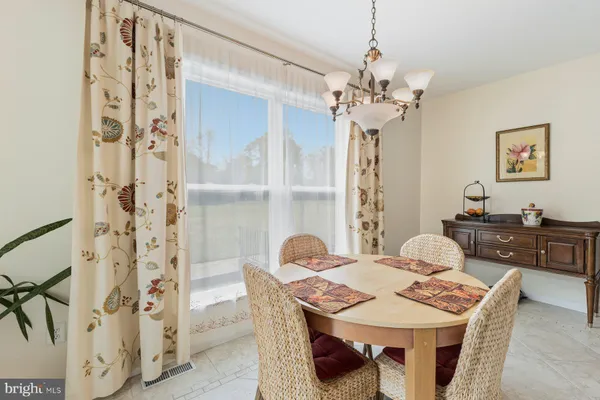 a kitchen with granite countertop a table chairs microwave and cabinets