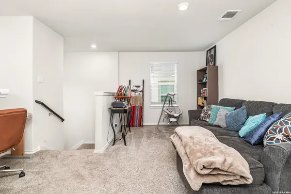 a living room with furniture a flat screen tv and a window