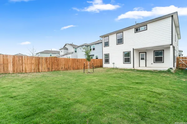 a view of a backyard with wooden fence