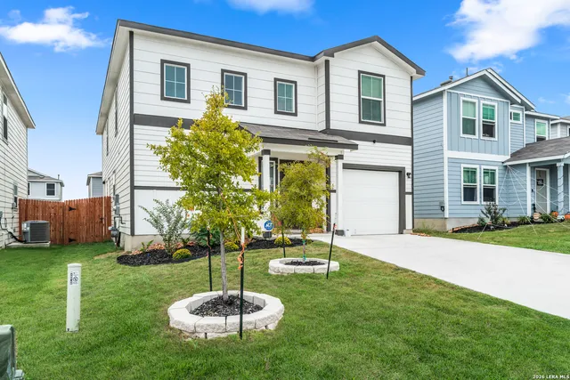 a backyard of a house with a fountain table and chairs