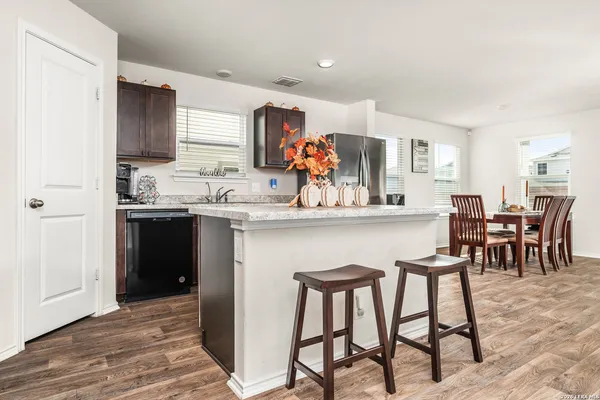 a kitchen with stainless steel appliances granite countertop table chairs sink and cabinets