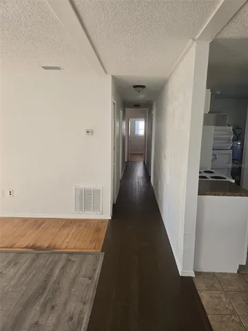 a view of a hallway with wooden floor