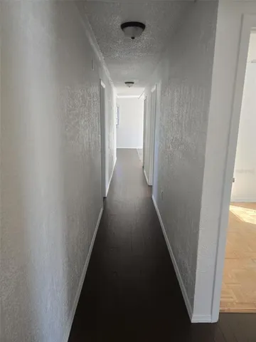 a view of a hallway with wooden floor