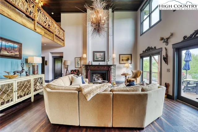 a living room with furniture a fireplace and a chandelier