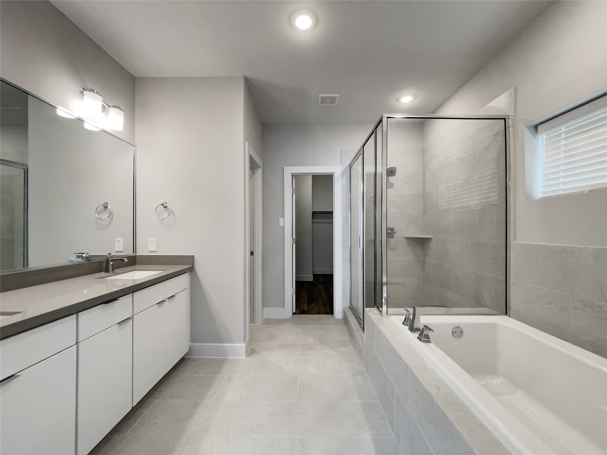 1270 North Post Oak Road, Unit A Houston, TX 77055 - Photo 24 of 33 Luxurious en-suite bathroom featuring a spacious walk-in shower, elegant double vanity, and a relaxing soaking tub.