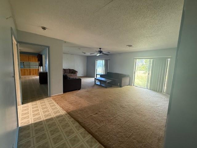 909 Railroad Street Rochester, TX 79544 - Photo 9 of 19 Living room featuring carpet, a textured ceiling, and ceiling fan