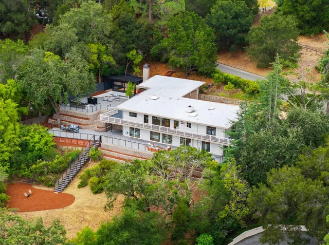 an aerial view of a house with a yard and lake view