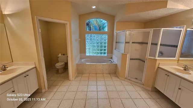 a bathroom with a tub a sink a mirror and a shower