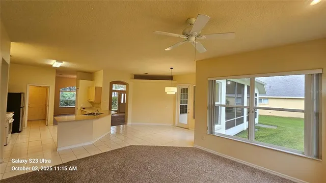 a view of a big room with wooden floor kitchen view and windows
