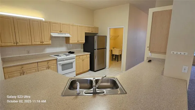 a kitchen with a sink cabinets and refrigerator
