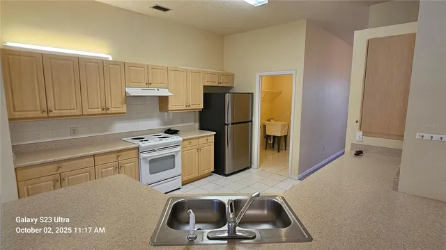 an empty room with a chandelier fan and windows