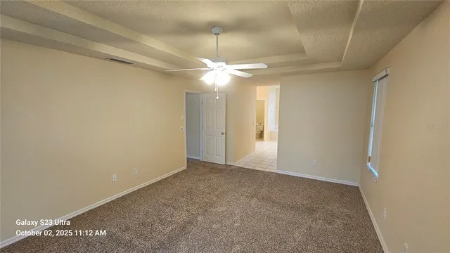 an empty room with a ceiling fan and a window