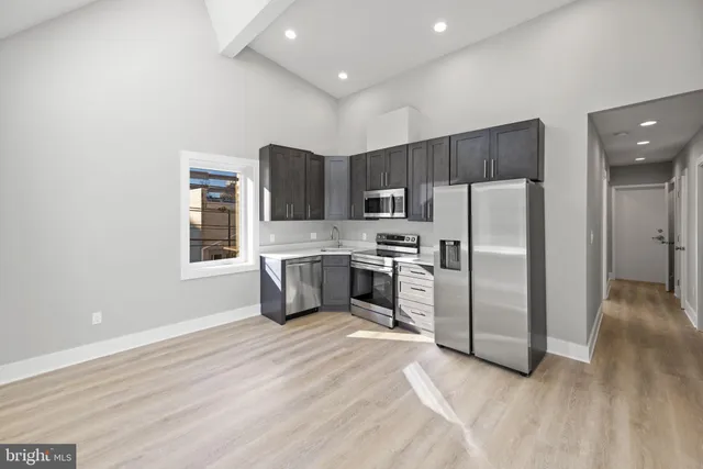 a kitchen with stainless steel appliances a refrigerator and a microwave