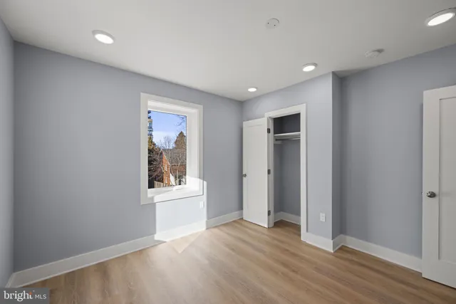 a view of a big room with wooden floor and windows