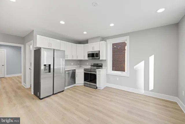 a kitchen with stainless steel appliances a refrigerator and a stove top oven