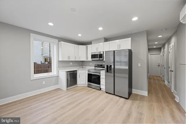 a kitchen with stainless steel appliances a refrigerator and a stove top oven