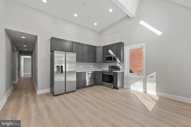 a kitchen with stainless steel appliances a refrigerator and a stove top oven