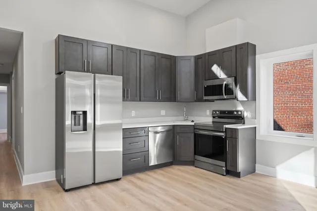 a kitchen with stainless steel appliances granite countertop a stove a refrigerator and a microwave