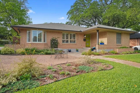 a front view of house with yard and trees around