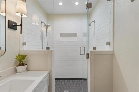 a bathroom with a tub shower and sink