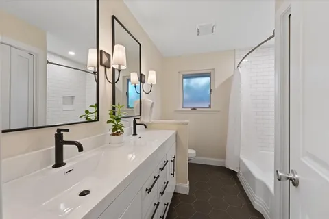 a bathroom with a double vanity sink and a mirror