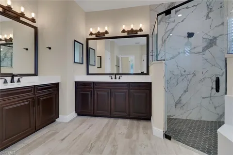 a spacious bathroom with a granite countertop double vanity sink and a mirror