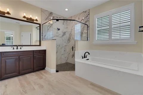 a bathroom with a bathtub sink shower and a mirror