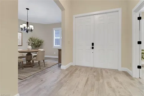 a view of a room with wooden floor table and chairs