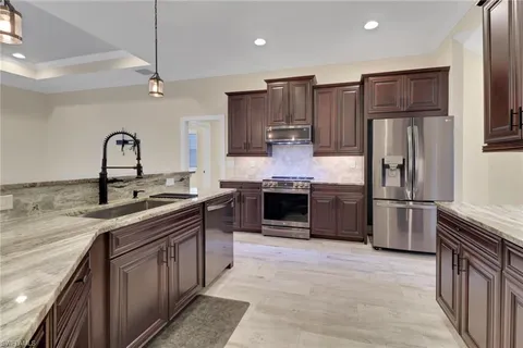 a kitchen with stainless steel appliances granite countertop a sink stove and refrigerator