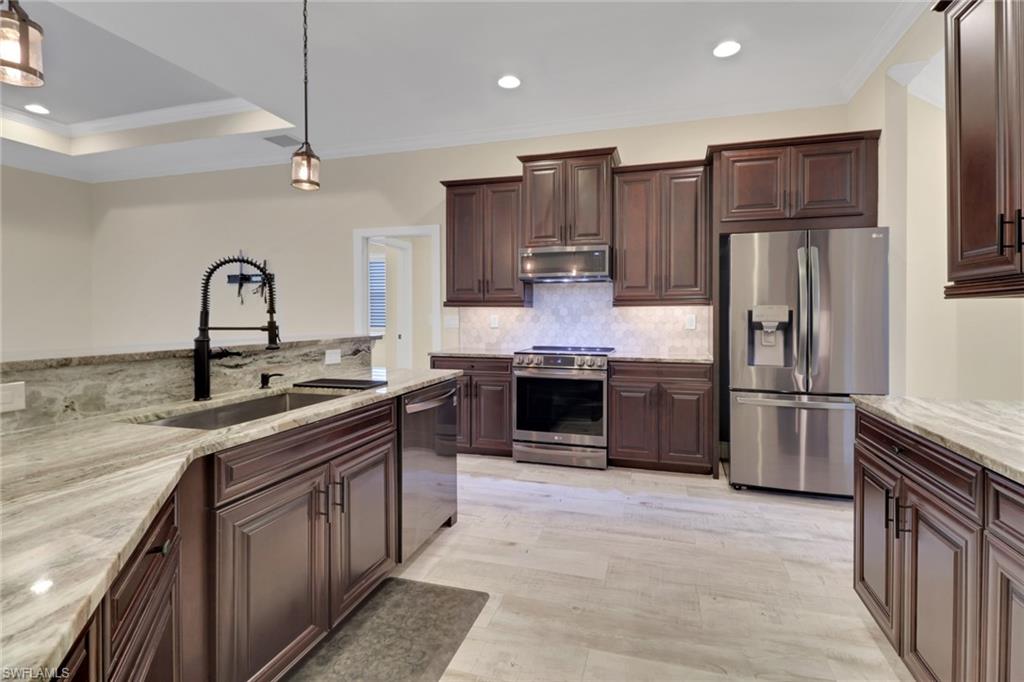 17094 Wrigley Circle Fort Myers, FL 33908 - Photo 9 of 33 a kitchen with stainless steel appliances granite countertop a sink stove and refrigerator