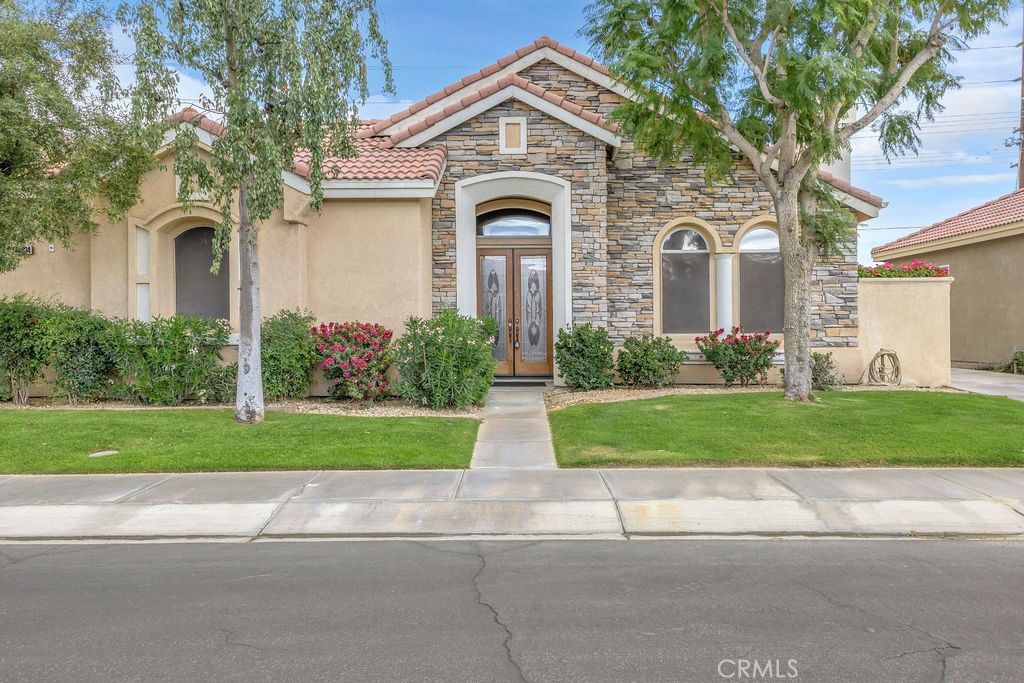 48834 Barrymore Street Indio, CA 92201 - Photo 1 of 1 a front view of a house with garden