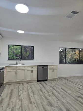 a view of a kitchen with wooden floor and electronic appliances