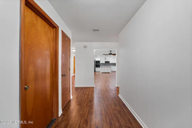 a view of a hallway with wooden floor