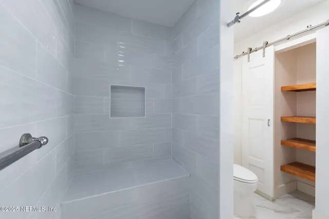 a bathroom with a shower a toilet and a sink